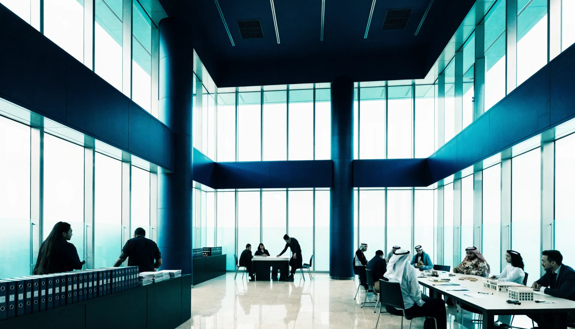 Three working zones connected inside a UAE institutional atrium: an Authority records counter, a consultant advisory table, and a service provider meeting area