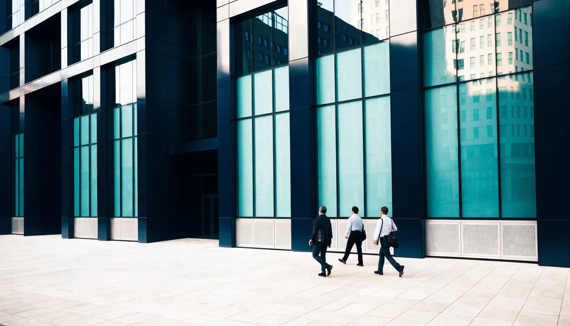 A contemporary UAE business district facade with business people crossing the plaza